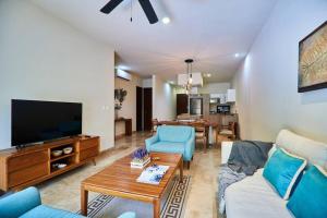 a living room with a couch and a tv at Zen Oasis Swim Up Condo Pool W Tiki Hut Bar + Gym in Tulum