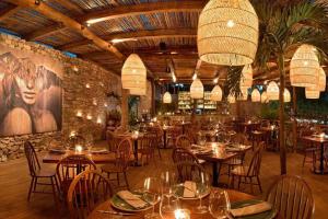 a restaurant with tables and chairs in a room at Zen Oasis Swim Up Condo Pool W Tiki Hut Bar + Gym in Tulum