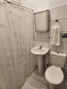 a bathroom with a toilet and a sink at Pousada Bartrô in Rio das Ostras +25 photos