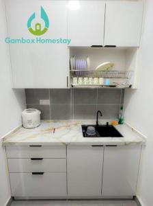a kitchen with white cabinets and a sink at Gembox Homestay near USIM#NETFLIX#WIFI100Mbps in Nilai