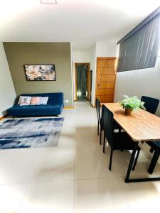 a living room with a table and a blue couch at Casa Sossego e Aconchego in Niterói