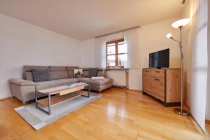 een woonkamer met een bank en een tv bij BergLiebe in Garmisch-Partenkirchen