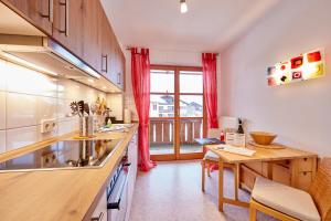 een keuken met een aanrecht en een tafel met een bureau bij BergLiebe in Garmisch-Partenkirchen
