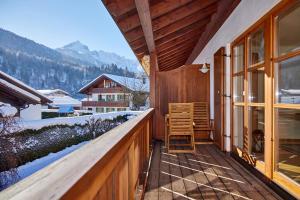 een houten balkon met uitzicht op een besneeuwde berg bij BergLiebe in Garmisch-Partenkirchen