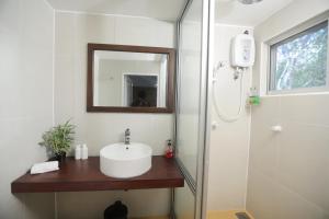 ein Badezimmer mit Waschbecken, Spiegel und Dusche in der Unterkunft The Backwaters Lodge in Wilpattu Nationalpark + 109 Fotos