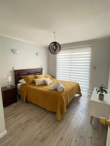 una camera da letto con un grande letto con una coperta gialla di Casa amoblada en sector residencial a Vallenar