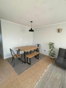 una sala da pranzo con tavolo, sedie e divano di Casa amoblada en sector residencial a Vallenar