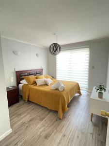 a bedroom with a large bed and a large window at Casa amoblada en sector residencial in Vallenar