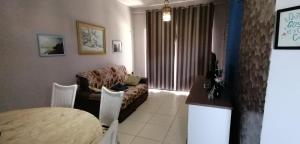 uma sala de estar com um sofá e uma mesa em THE FOUNTAINS 110 - Apartamento em lindo condomínio pé na areia da Praia das Fontes em Beberibe - CE em Beberibe