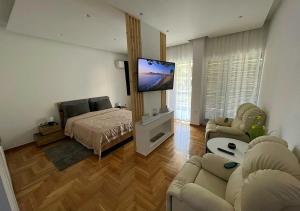 ein Wohnzimmer mit Bett und Flachbildfernseher in der Unterkunft Sea View Studio in Athen