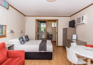 a hotel room with a bed and a table at Marion Holiday Park in Adelaide