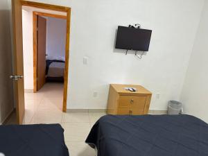 ein Schlafzimmer mit einem Bett und einem TV an der Wand in der Unterkunft Habitaciones ENMA in Ciudad Juárez