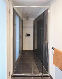 La salle de bains est pourvue d'une douche à l'italienne et d'une porte en verre. dans l'établissement Cityscape Trendsetter - Contemporary Chic with Pool, à Melbourne