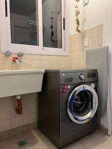 a washing machine in a bathroom with a sink at DEPARTAMENTO AHNEN CORDOBA - Cerca Instituto Cardiologico, Ferial Cordoba, Hospital Privado Cerro y Sanatorio Allende in Cordoba