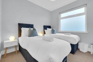 two beds in a room with a window at Station Skyline One By My Getaways in Brighton & Hove