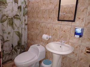 La salle de bains est pourvue de toilettes et d'un lavabo. dans l'établissement Nambí Rooms, à Nambí