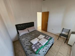 a bedroom with a bed with pillows and a chair at La Juanita in Junín de los Andes
