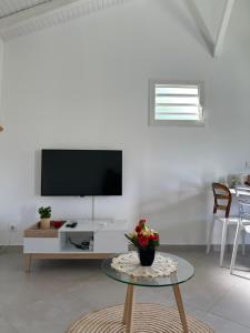 a living room with a tv and a table at Bungalow Ixora in Les Abymes