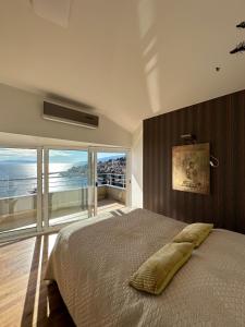 a bedroom with a large bed with a view of the ocean at Villa Dinka VIP apartmani in Opatija