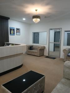 ein Wohnzimmer mit einem Sofa und einem Kronleuchter in der Unterkunft TZ SATELLITE HOTEL, Kota Bharu in Kota Bharu
