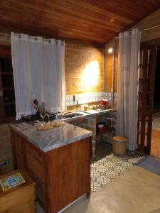 eine Küche mit einer Spüle und einer Arbeitsplatte in der Unterkunft Chalé Calêndula - charme junto à natureza in Santo Antônio do Pinhal