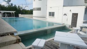 una piscina con banco y una casa blanca en See Belize Sea View Vacation Rentals, en Ciudad de Belice