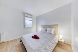 een rood hart zittend op een bed in een slaapkamer bij Appartement F2 haut de Montreuil in Montreuil