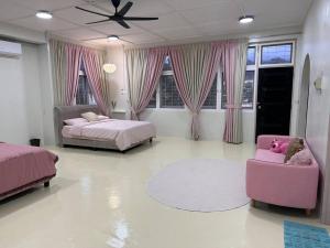 1 dormitorio con 2 camas y silla rosa en The Hidden 7, en Taiping