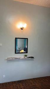 a mirror on a white wall with a shelf at The Hidden 7 in Taiping
