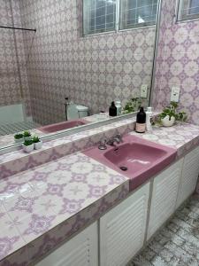 uma casa de banho com um lavatório rosa e um espelho. em The Hidden 7 em Taiping