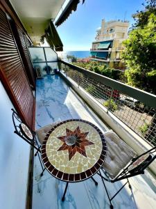 uma mesa e cadeira numa varanda com vista para o oceano em Sea View Studio em Atenas