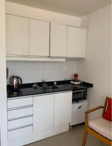 eine Küche mit weißen Schränken und einer Arbeitsplatte in der Unterkunft Studio Park in Montevideo