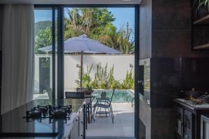 a kitchen with a view of a patio with an umbrella at Alto padrão piscina aquecida em Balneário Camboriú in Balneário Camboriú