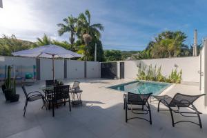 a patio with a table and chairs and a pool at Alto padrão piscina aquecida em Balneário Camboriú in Balneário Camboriú