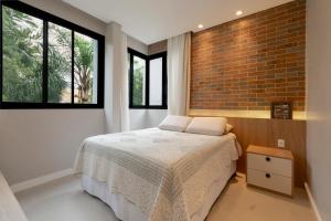 a bedroom with a bed and a brick wall at Alto padrão piscina aquecida em Balneário Camboriú in Balneário Camboriú +70 photos