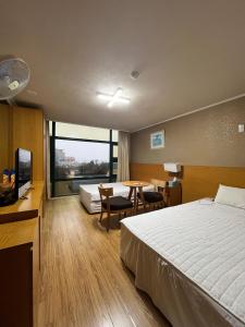 een hotelkamer met een bed en een tafel met stoelen bij Seongsan Motel in Seogwipo