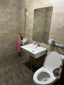 een badkamer met een toilet, een wastafel en een spiegel bij Seongsan Motel in Seogwipo
