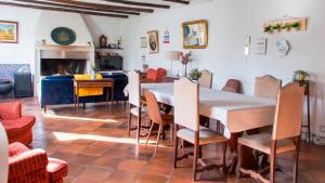 a dining room with a table and chairs and a fireplace at Casa da Paz in Labrugeira