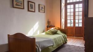 a bedroom with a bed and a window and a door at Casa da Paz in Labrugeira
