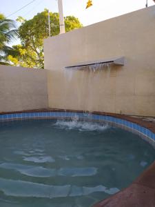 a swimming pool with a water fountain at Flat Tamandaré in Tamandaré