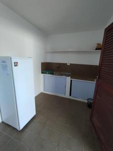 a kitchen with a white refrigerator and a sink at Flat Tamandaré in Tamandaré