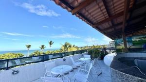 un balcón con mesas y sillas y el océano en Ambassador Flat, en João Pessoa