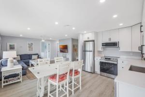 a kitchen and living room with a table and chairs at New Listing! Beach Walk Newly Renovated - Walk To Vanderbilt Beach! in Naples