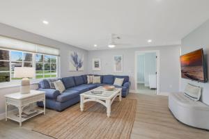 a living room with a blue couch and a table at New Listing! Beach Walk Newly Renovated - Walk To Vanderbilt Beach! in Naples
