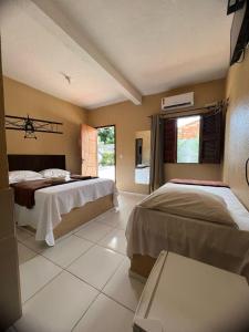 a bedroom with two beds and a window at Hotel Pinto Martins in Camocim