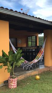 a hammock in front of a house with a plant at Kalena Suítes in Lençóis