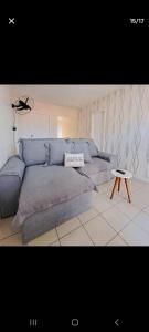 uma sala de estar com um sofá azul e uma mesa em Conforto em local privilegiado em Itajaí