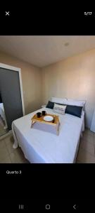 uma cama branca com uma bandeja em cima em Conforto em local privilegiado em Itajaí
