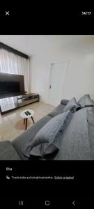 uma sala de estar com um sofá e uma televisão em Conforto em local privilegiado em Itajaí