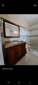 uma casa de banho com um lavatório, um WC e um espelho. em Conforto em local privilegiado em Itajaí